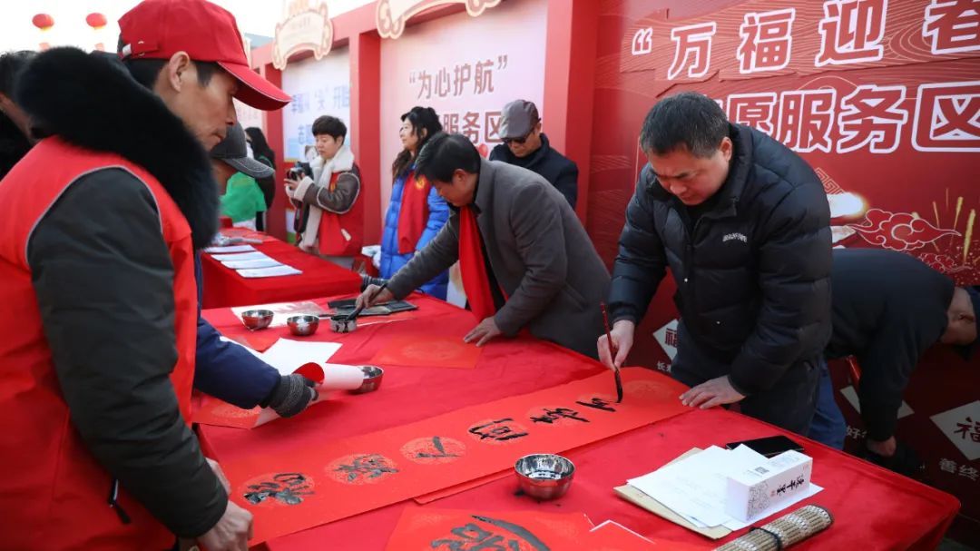 志愿者在集市上义写春联送祝福。